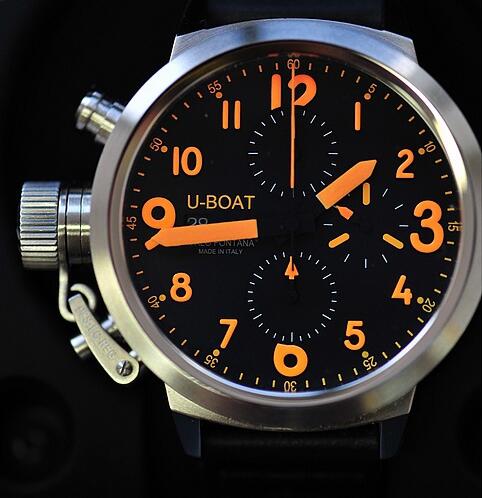 The orange hands and hour markers are striking on the black dial.